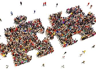 Two pieces of a giant jigsaw composed of groups of people, signifying two companie coming together